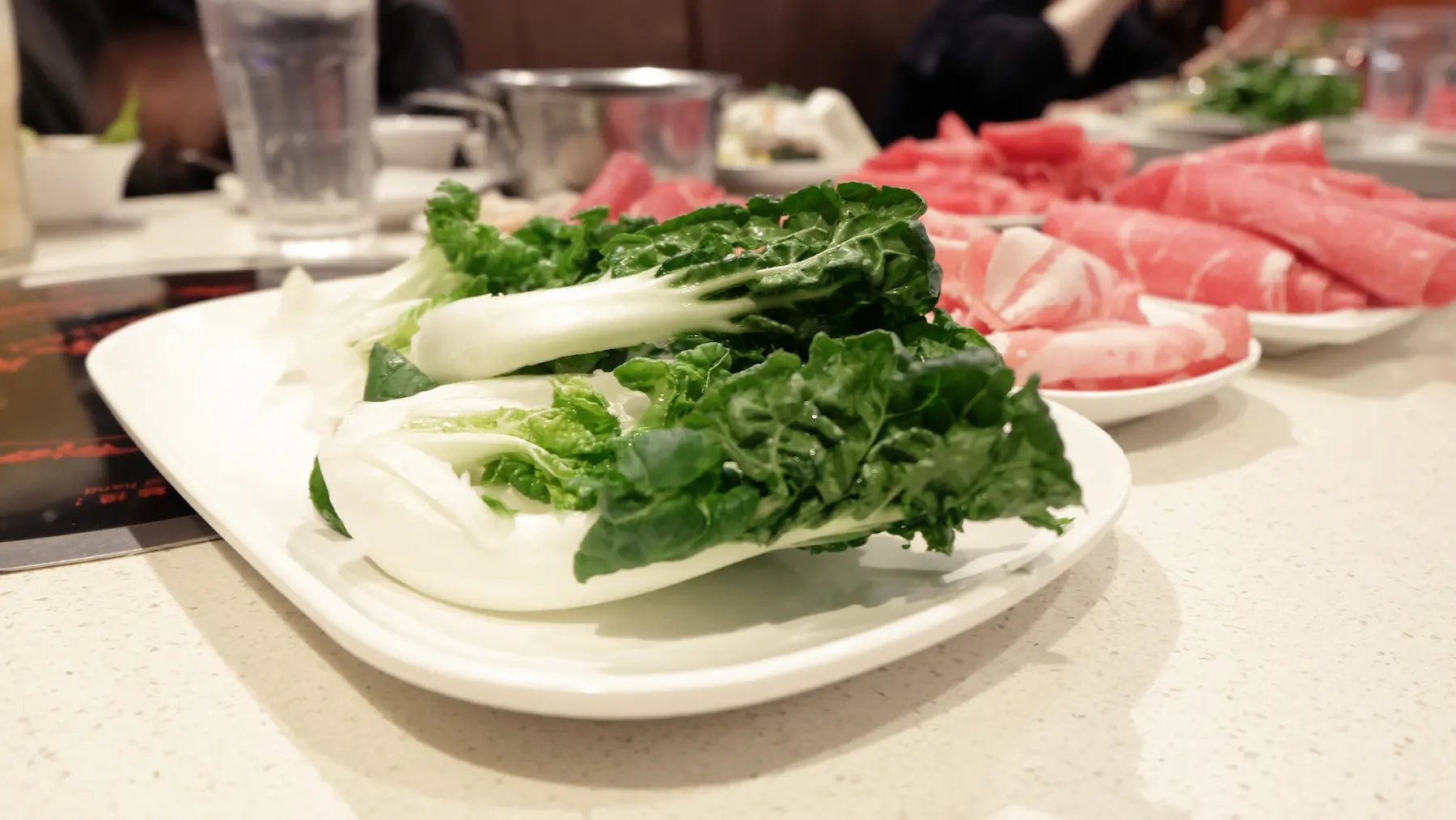 A plate of bok choy in in hotpot place